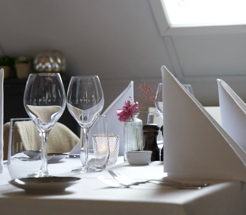 Zonovergoten eettafel met elegante tafelschikking en frisse bloemen bij La Bonne Vie.